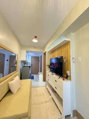 a living room with a couch and a flat screen tv at CASA BELLA - Shore 3 MOA, Pasay in Manila