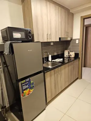 a kitchen with a refrigerator with a plate of food on it at Condo next door 3 in Manila