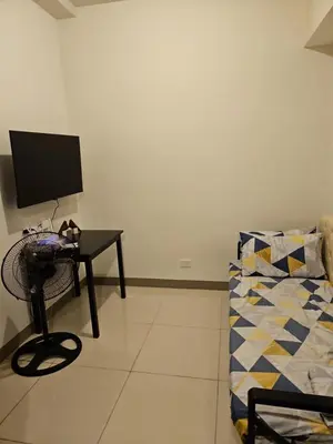 a room with a desk with a computer and a couch at Condo next door 3 in Manila