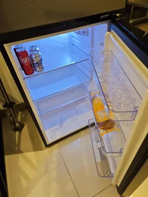 an open refrigerator with drinks and sodas in it at Condo next door 3 in Manila