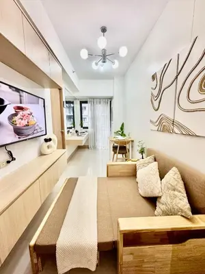 a living room with a couch and a tv at Minimalist Chic Condo near MOA-Shore3 Tower2 in Manila