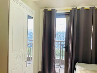 a bedroom with a window with a view of a building at 1126 S Residences SMDC Condo near W Mall & MOA by Prime Stay in Manila