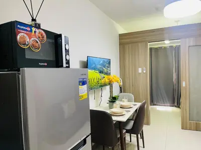 a kitchen and dining room with a refrigerator and a table at 1126 S Residences SMDC Condo near W Mall & MOA by Prime Stay in Manila
