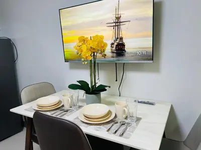 a dining room table with a painting of a ship at 1126 S Residences SMDC Condo near W Mall & MOA by Prime Stay in Manila