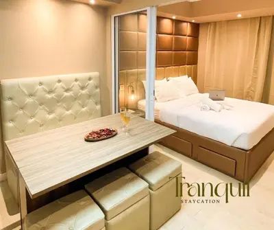 a bedroom with a bed and a table with a laptop at Azure Staycation in Manila