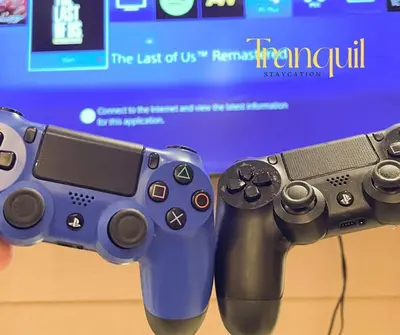 a person holding a video game controller in front of a tv at Azure Staycation in Manila