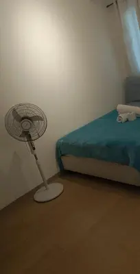 a bedroom with a fan next to a bed at The Embassy Pods in Manila
