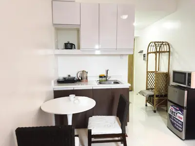 a small kitchen with a table and a counter top at The Embassy Pods in Manila