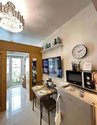 a kitchen with a table and a clock on the wall at Condo near MOA and NAIA in Manila