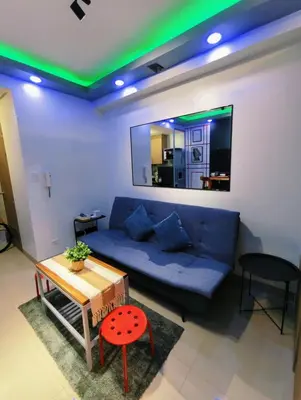 a living room with a blue couch and a table at Shore 2 Tower 3 Modern Loft Near Mall of Asia in Manila