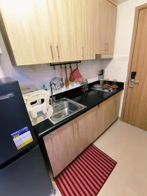 a kitchen with wooden cabinets and a sink at Shore 2 Tower 3 Modern Loft Near Mall of Asia in Manila