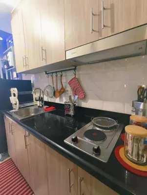 a kitchen counter with a stove and a sink at Shore 2 Tower 3 Modern Loft Near Mall of Asia in Manila