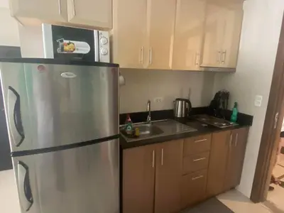 a kitchen with a stainless steel refrigerator and a microwave at One Palm Tree Villas Studio w fast WiFi, across from NAIA Terminal 3 in Manila