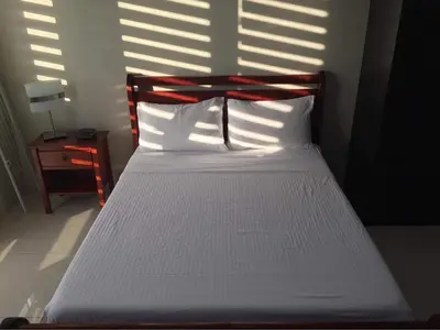a bedroom with a bed with white sheets and sunlight at One Palm Tree Villas Studio w fast WiFi, across from NAIA Terminal 3 in Manila