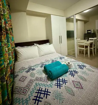 a bedroom with a bed with a blue pillow on it at Verte Hideaway at Azure Residences - Urban Escape in Manila