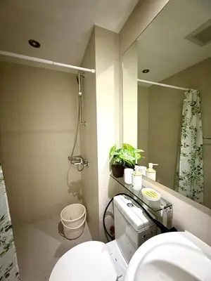 a bathroom with a toilet and a sink and a mirror at Verte Hideaway at Azure Residences - Urban Escape in Manila