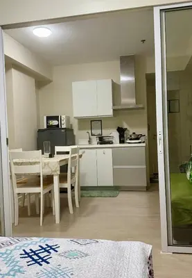 a kitchen and dining room with a table and chairs at Verte Hideaway at Azure Residences - Urban Escape in Manila