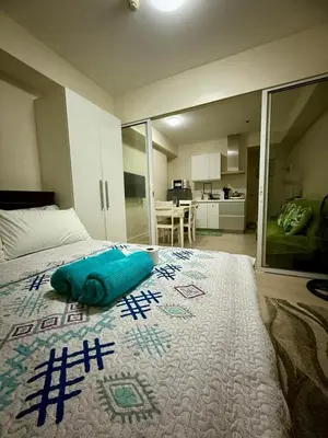 a bedroom with a bed with a blue pillow on it at Verte Hideaway at Azure Residences - Urban Escape in Manila
