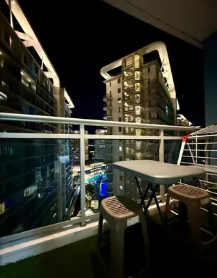 a table and chairs on a balcony at night at Verte Hideaway at Azure Residences - Urban Escape in Manila