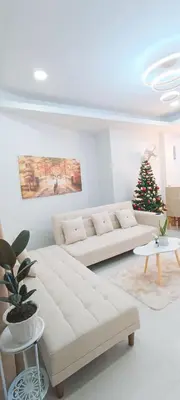 a living room with a white couch and a christmas tree at Casa Viana - Modern House Upto 300mbps Wi-fi with Netflix, FREE Parking in Cabuyao