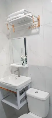 a white bathroom with a sink and a toilet at Casa Viana - Modern House Upto 300mbps Wi-fi with Netflix, FREE Parking in Cabuyao