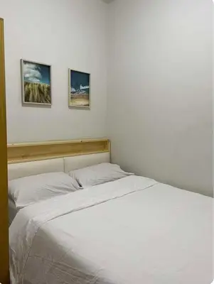 a bedroom with a white bed with three pictures on the wall at S residence, Mall of Asia Area in Manila