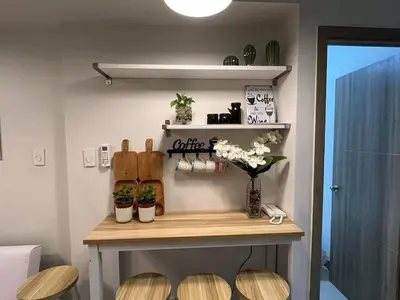a room with a table and some plants and flowers at S residence, Mall of Asia Area in Manila