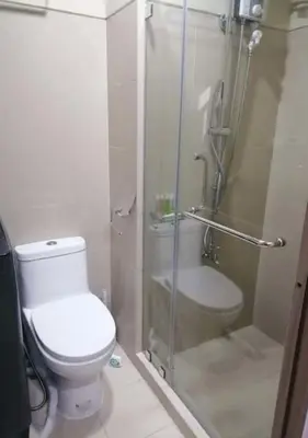 a bathroom with a toilet and a glass shower at S residence, Mall of Asia Area in Manila