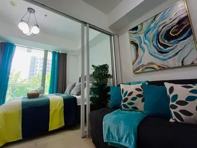 a living room with a couch and a mirror at Maldives Suites, Azure Urban Resorts and Residences in Manila