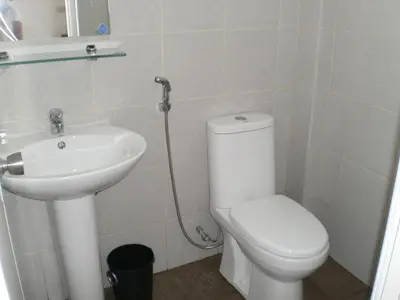 a bathroom with a toilet and a sink at The Palines Apartment Hotel near Brittany Palazzo Villar City in Manila