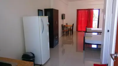 a kitchen with a white refrigerator in a room at The Palines Apartment Hotel near Brittany Palazzo Villar City in Manila