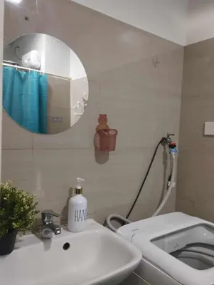 a bathroom with a sink and a toilet and a mirror at Cozy Apartment in Mall of Asia in Manila