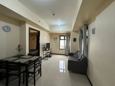 a living room with a table and a couch at 1 BEDROOM Staycation in Pasay in Manila