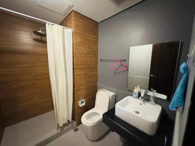 a bathroom with a white toilet and a sink at 1 BEDROOM Staycation in Pasay in Manila