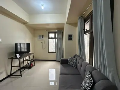 a living room with a couch and a television at 1 BEDROOM Staycation in Pasay in Manila