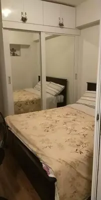 a bedroom with two beds and a mirror at BRIO TOWERS condominuim in Manila