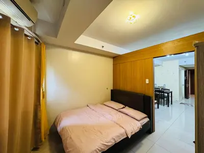 a bedroom with a bed and a dining room at Shell Residences Tower A in Manila