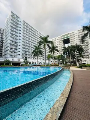 a large swimming pool in front of a large building at Shell Residences Tower A in Manila