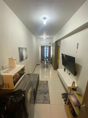 a living room with a couch and a television at Cozy Flat in Pasay City in Manila