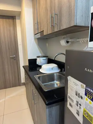 a small kitchen with a sink and a refrigerator at Cozy Flat in Pasay City in Manila