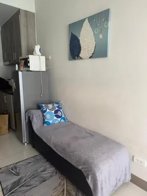 a bedroom with a bed with a pillow on it at Cozy Flat in Pasay City in Manila