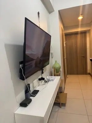 a large flat screen tv hanging on a wall at Cozy Flat in Pasay City in Manila