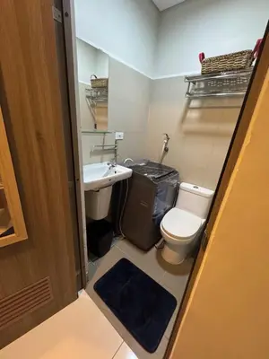 a small bathroom with a toilet and a sink at Cozy Flat in Pasay City in Manila