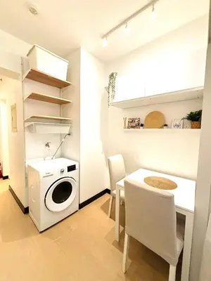 a kitchen with a washing machine and a table at Free Car Parking - Sheridan North 1BR Apt near BGC in Manila