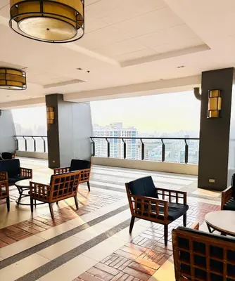 a lobby with chairs and tables and a view at Free Car Parking - Sheridan North 1BR Apt near BGC in Manila