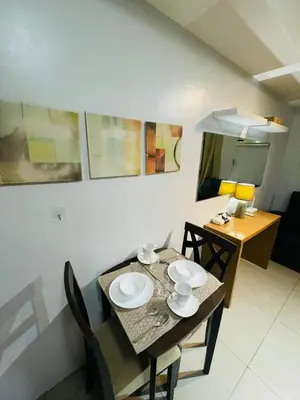 a dining room table and chairs with a table and a dining room at Cozy 1 Bedroom Condo Unit in Manila