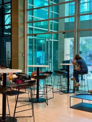 a woman sitting at tables in a room with windows at Loft in Boni - Work friendly - Cityview - up to 8pax in Manila