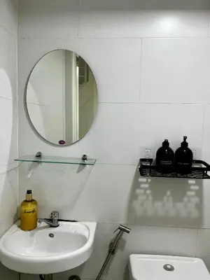 a white bathroom with a sink and a mirror at Loft in Boni - Work friendly - Cityview - up to 8pax in Manila