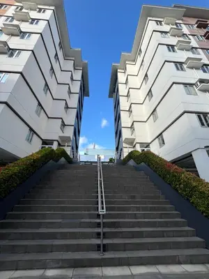 two tall white buildings with stairs between them at Aras Solace Place in Trece Martires