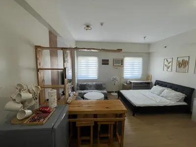 a living room with a bed and a table at Aras Solace Place in Trece Martires